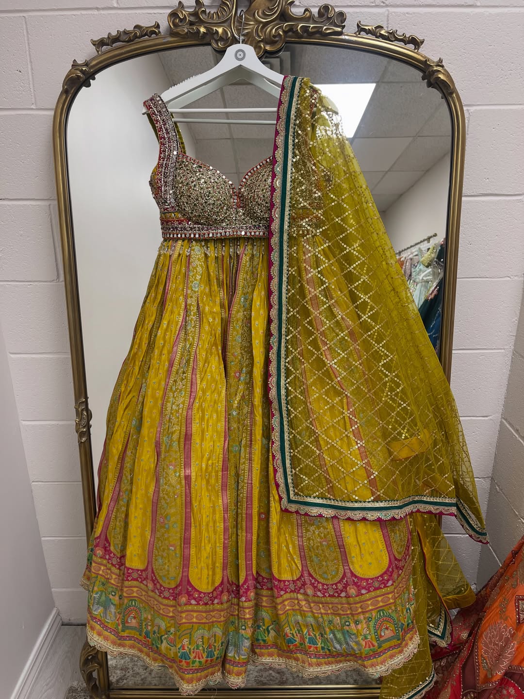Mustard yellow printed lehenga set with embellished blouse and sequined net dupatta for weddings and festive occasions.